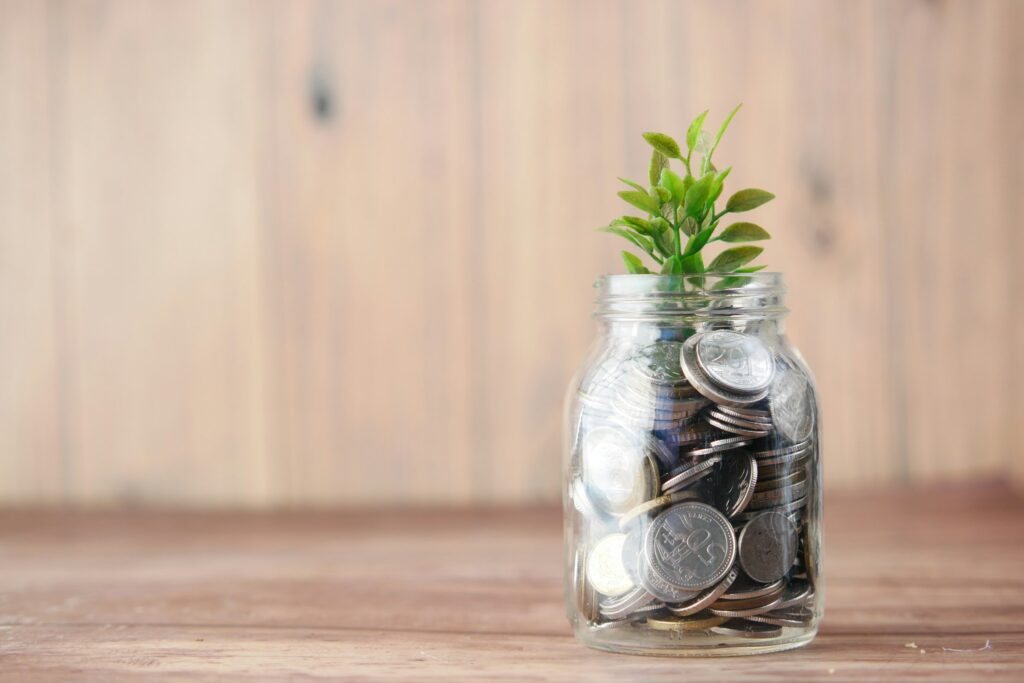 Tarro de cristal con monedas y una planta creciendo